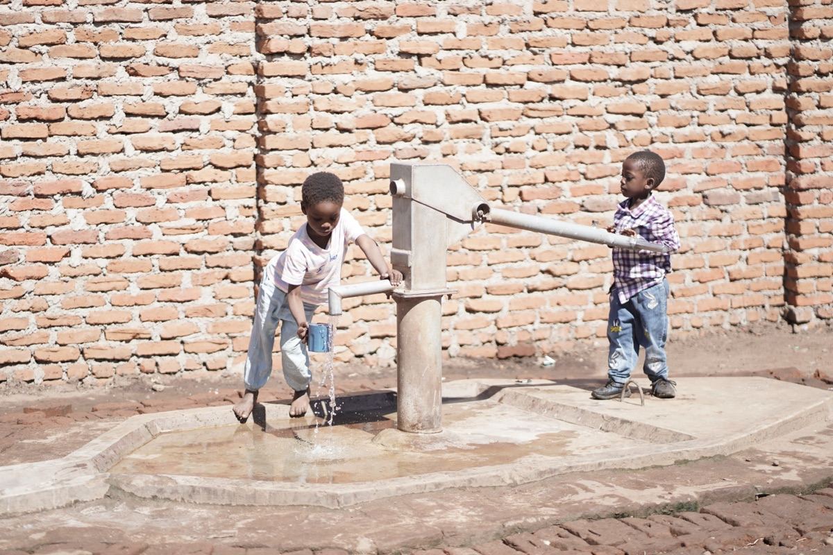 Boys collecting clean water from a well